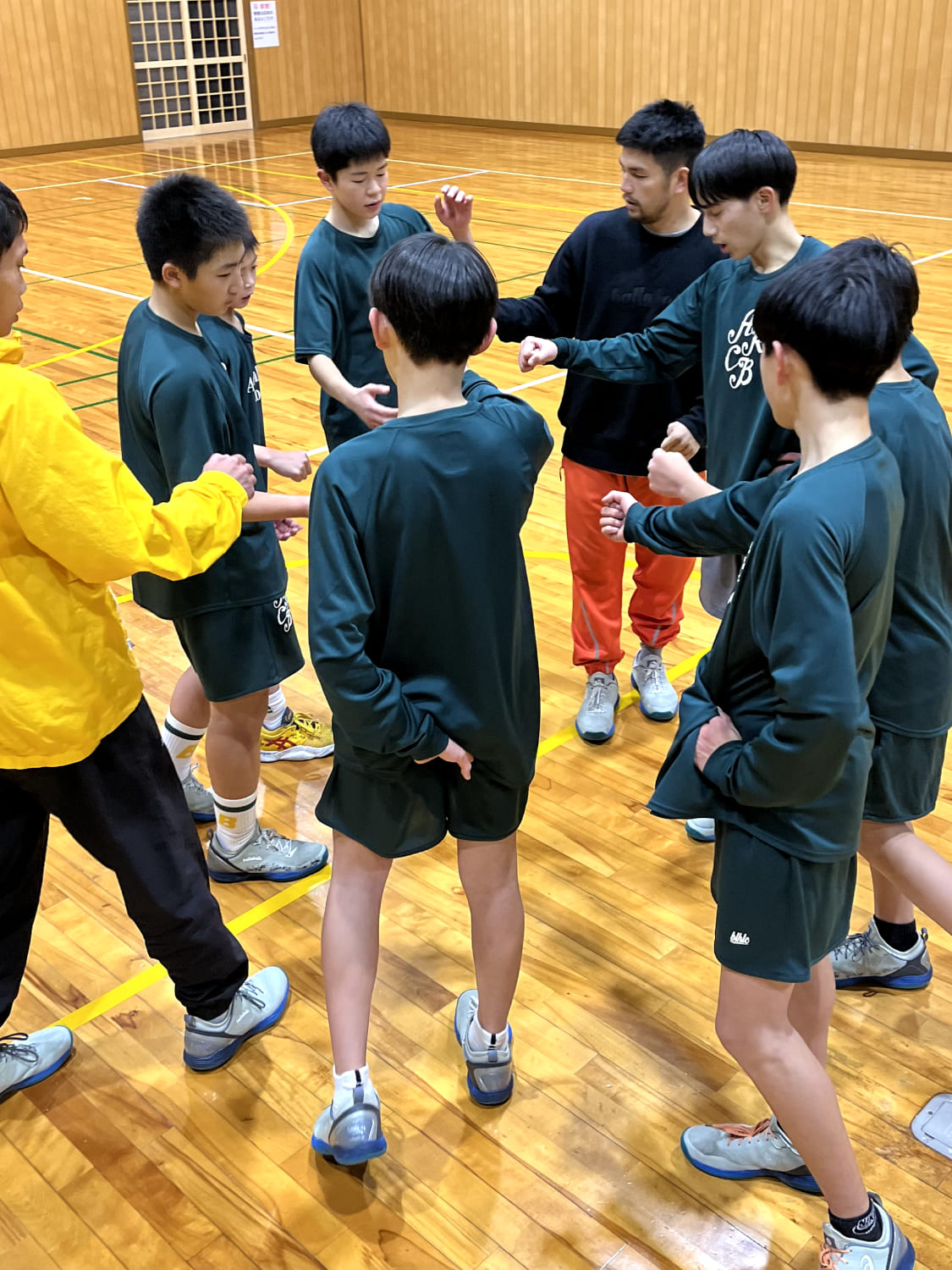 スクール生たちが輪を作って集まっている様子の写真