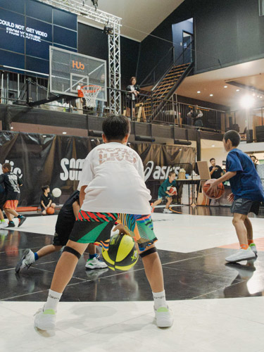 スクール生がコーチの実演を見ている様子の写真