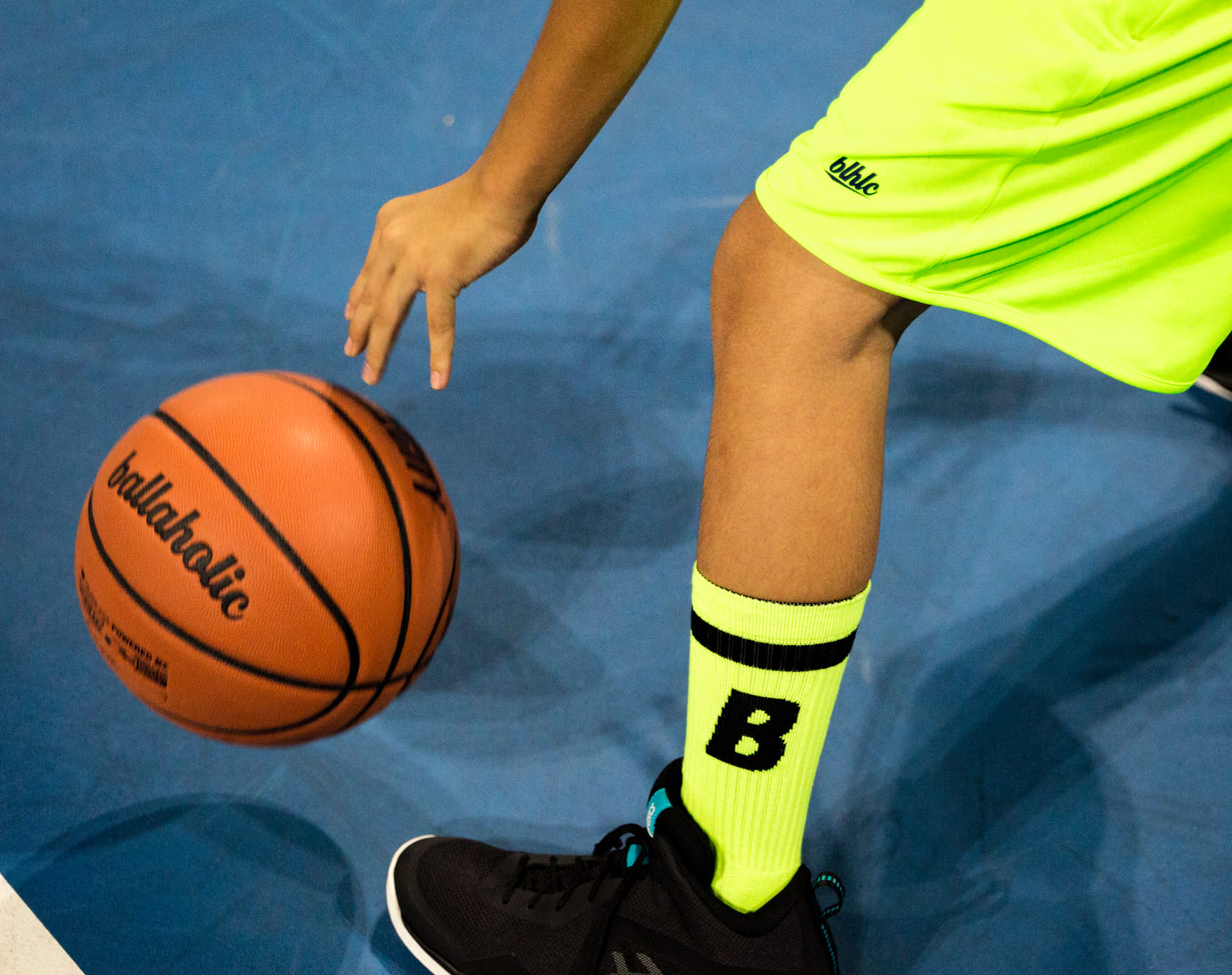 黄色のパンツ・黄色の靴下を履いた人がドリブルをしている写真