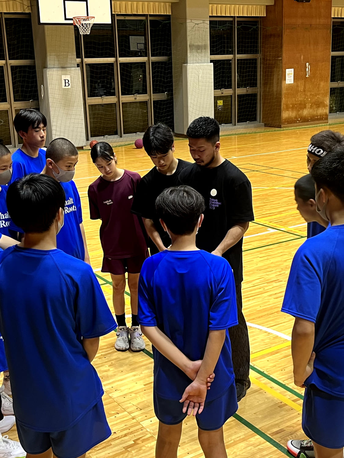 スクール生がコーチの話を聞いている様子の写真