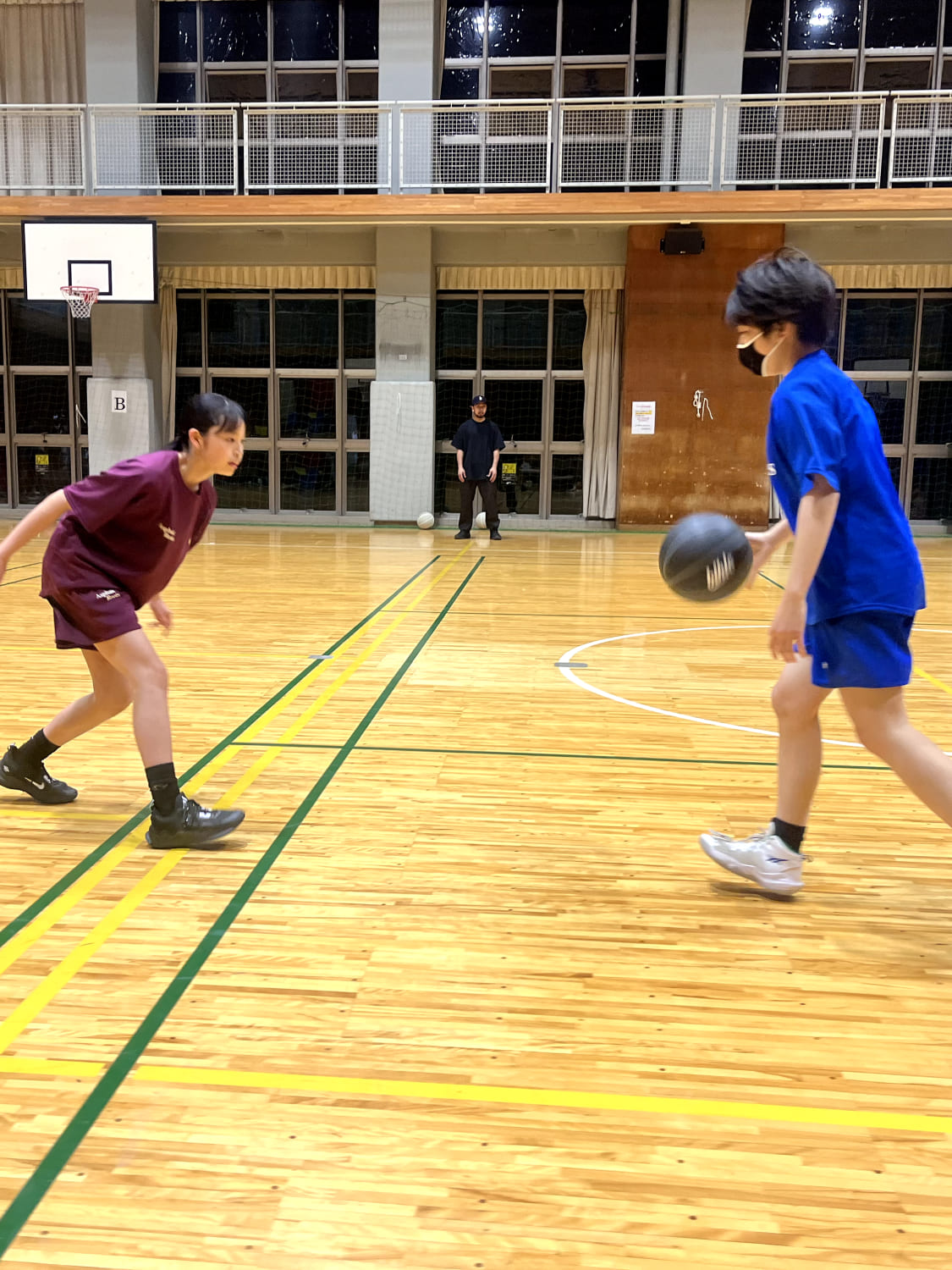 1on1で女の子と男の子がバスケットボールをしている様子の写真