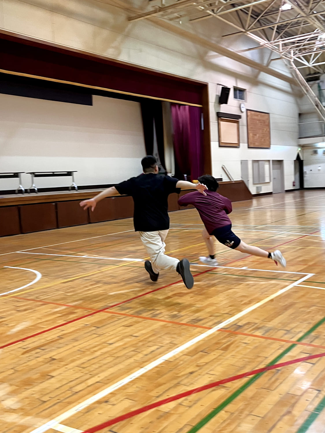 コーチとスクール生が1on1でバスケットボールをしている様子の写真