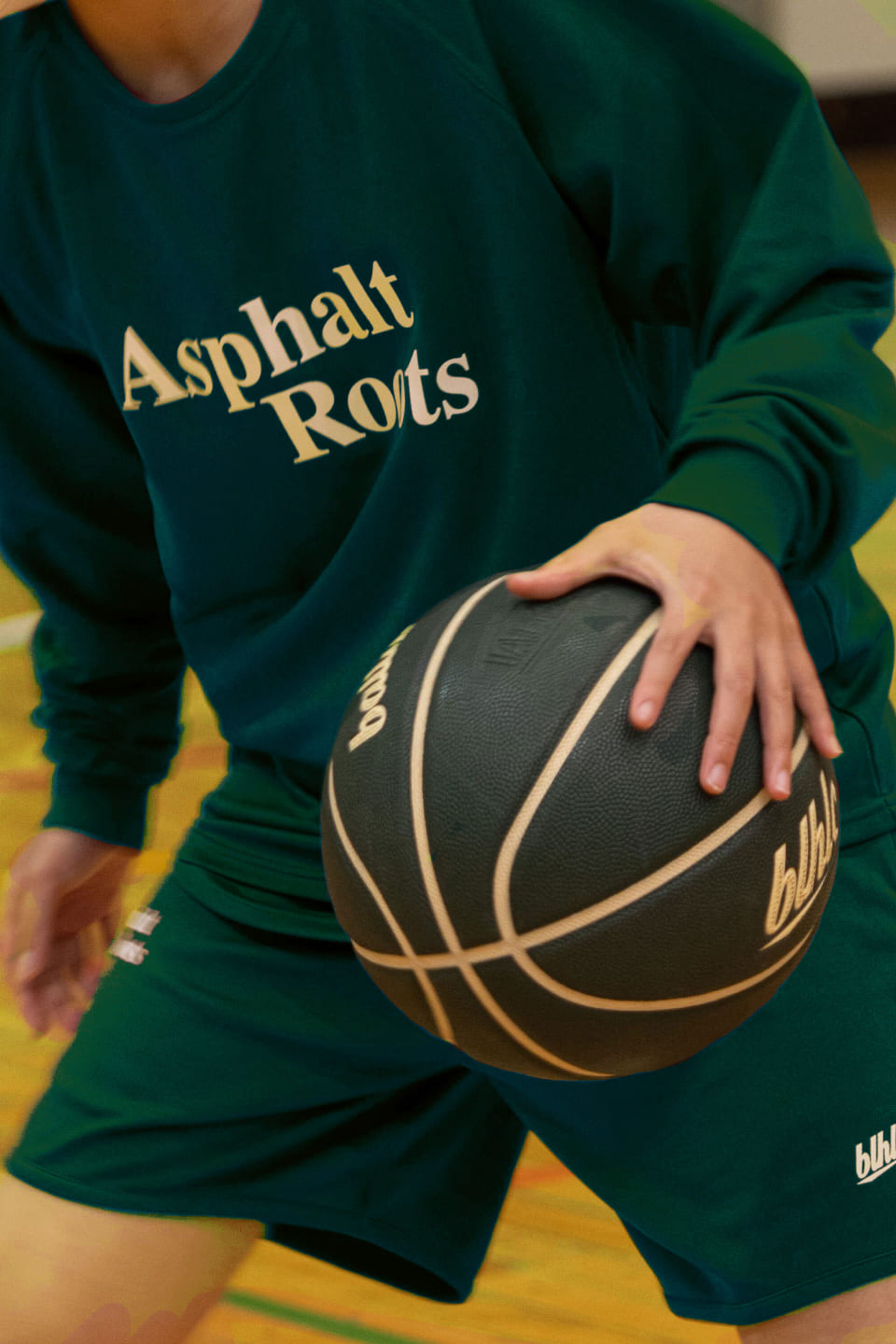 緑のロングTシャツを着た人がドリブルをしている様子の写真